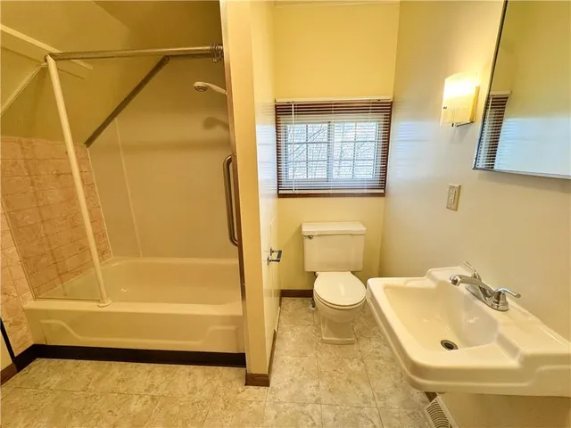 a bathroom with a sink a toilet a shower curtain and a bath tub