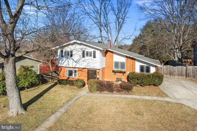 a front view of a house with a yard covered in snow