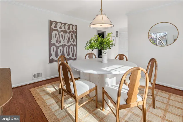 a kitchen with stainless steel appliances granite countertop a refrigerator a stove a sink and white cabinets with wooden floor