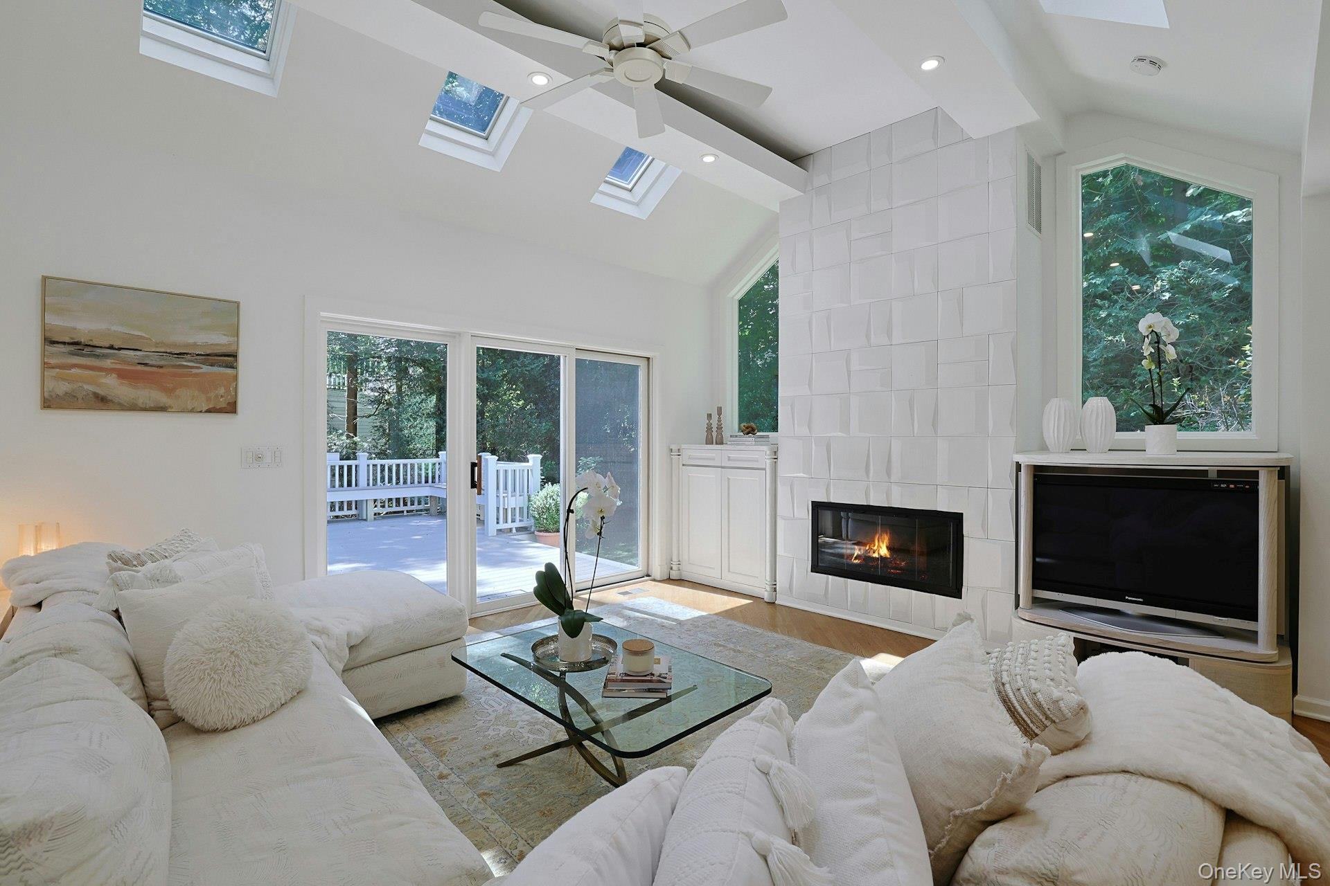17 Elm Road Scarsdale, NY 10583 - Photo 16 of 38 The expansive family room offers plenty of room to relax and entertain, complemented by built-ins, a gas fireplace and views of the surrounding greenery.