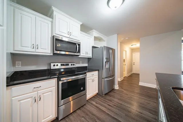 a kitchen with stainless steel appliances granite countertop a stove a refrigerator and a microwave