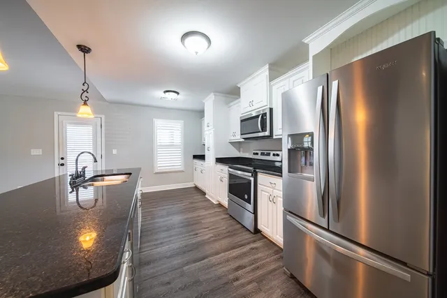 a kitchen with sink refrigerator and cabinets
