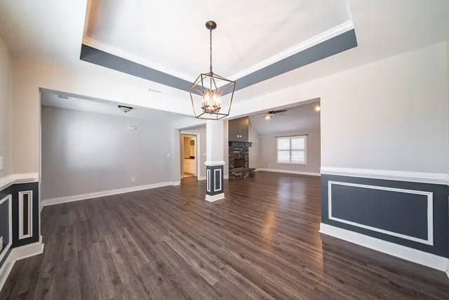 a view of a room with wooden floor fireplace and windows