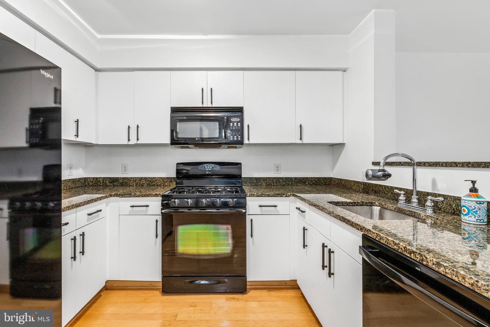 1000 New Jersey Avenue Southeast, Unit 608 Washington, DC 20003 - Photo 5 of 28 a kitchen with a stove a sink and a microwave
