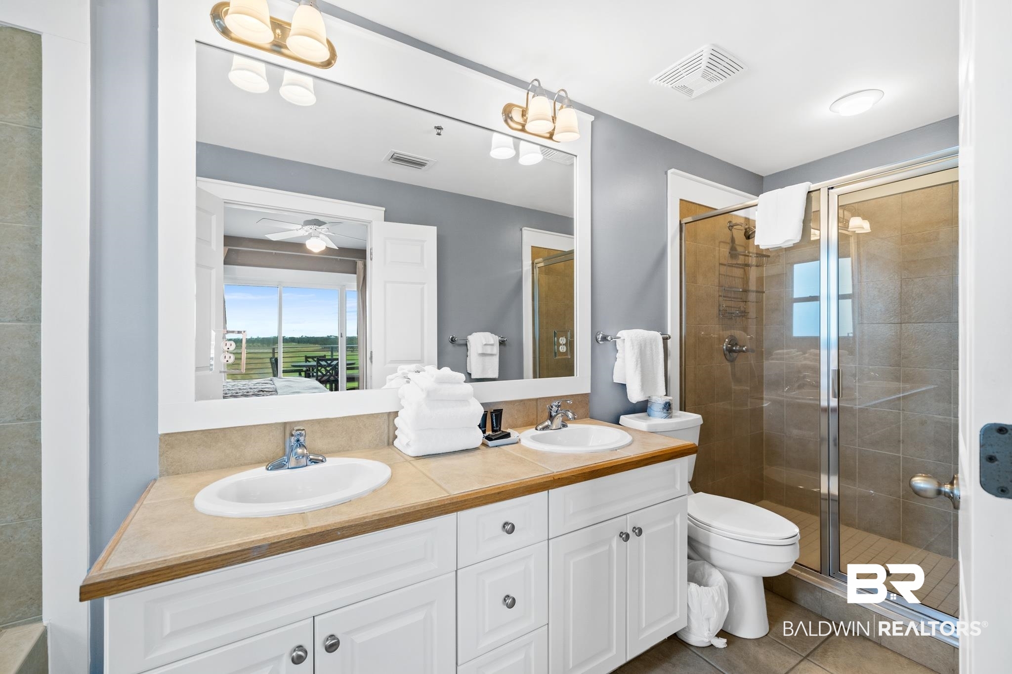 815 Plantation Road, Unit 405 Gulf Shores, AL 36542 - Photo 18 of 39 Bathroom featuring toilet, ceiling fan, tile patterned flooring, walk in shower, and vanity