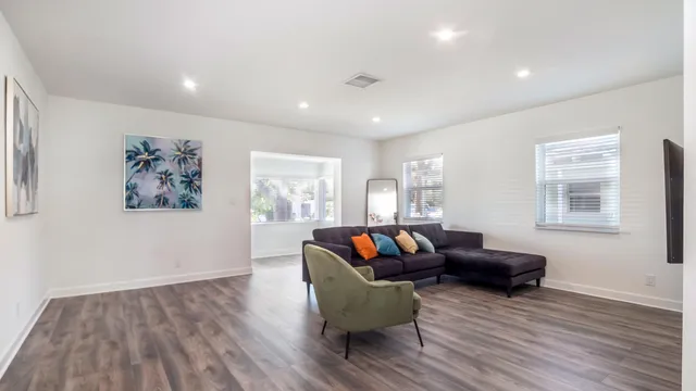 a living room with furniture and a wooden floor