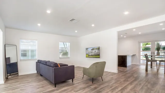a living room with furniture and a wooden floor
