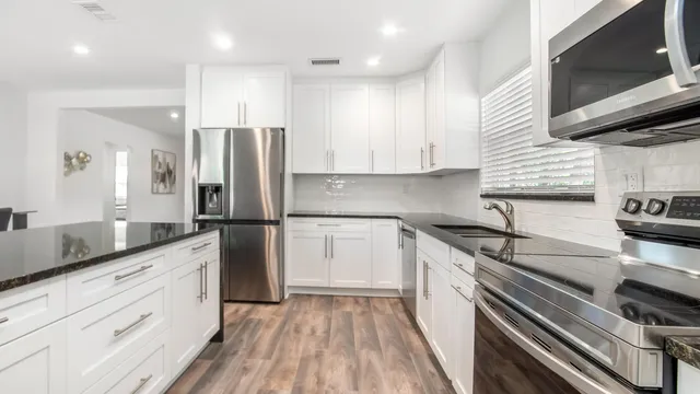 a kitchen with a sink stainless steel appliances and cabinets