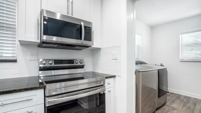 a view of kitchen with a stove and a microwave