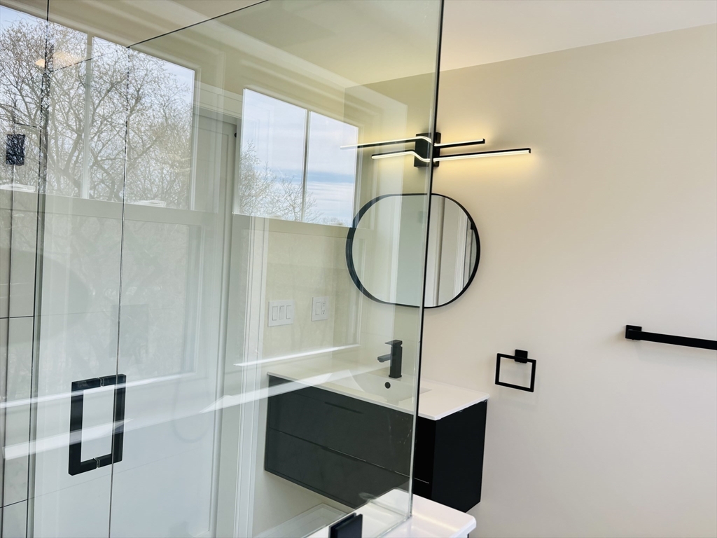 19 Maverick Street, Unit 19 Dedham, MA 02026 - Photo 8 of 13 a bathroom with a sink a mirror and shower