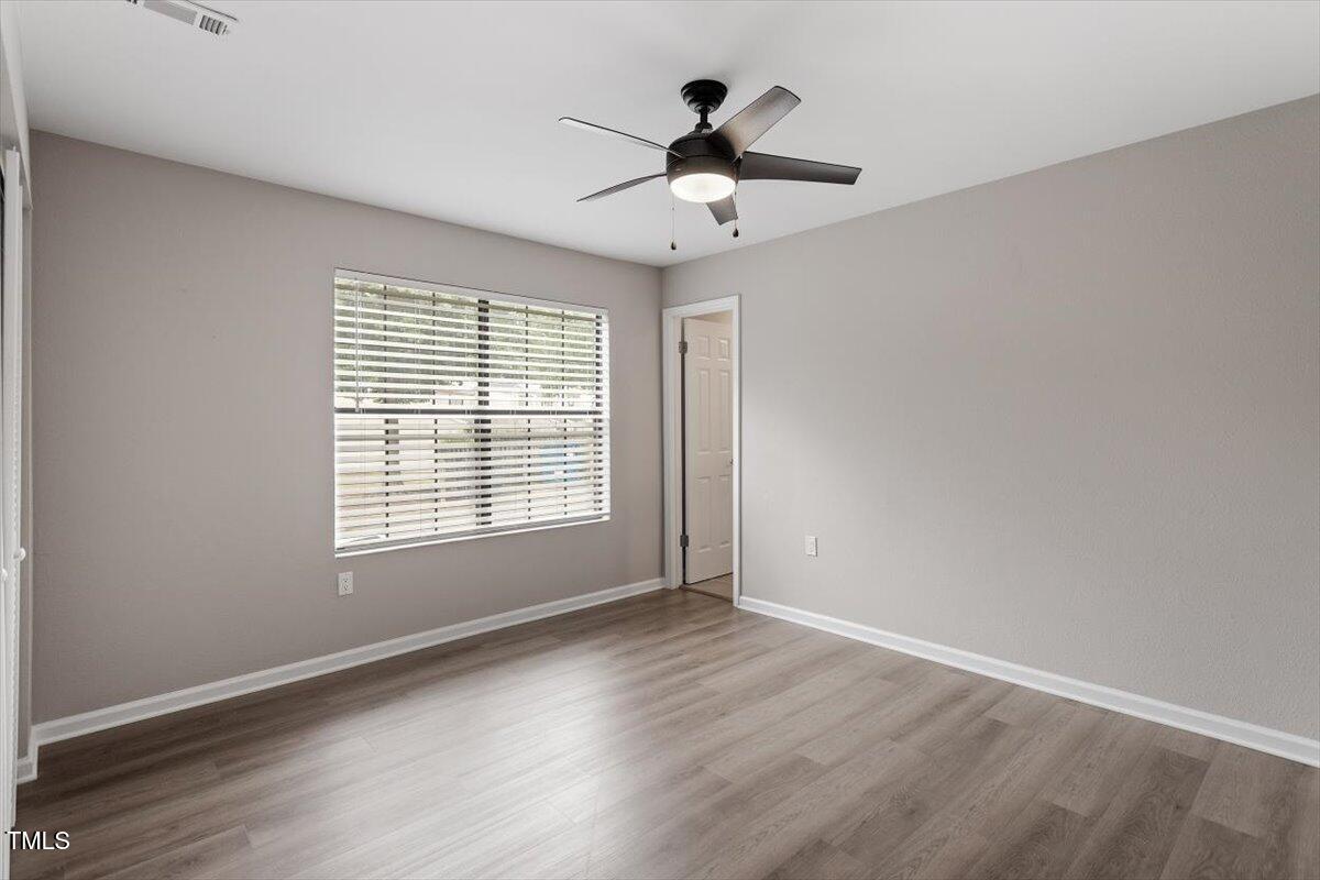 7771 Falcon Rest Circle Raleigh, NC 27615 - Photo 28 of 34 a view of an empty room with wooden floor and a window