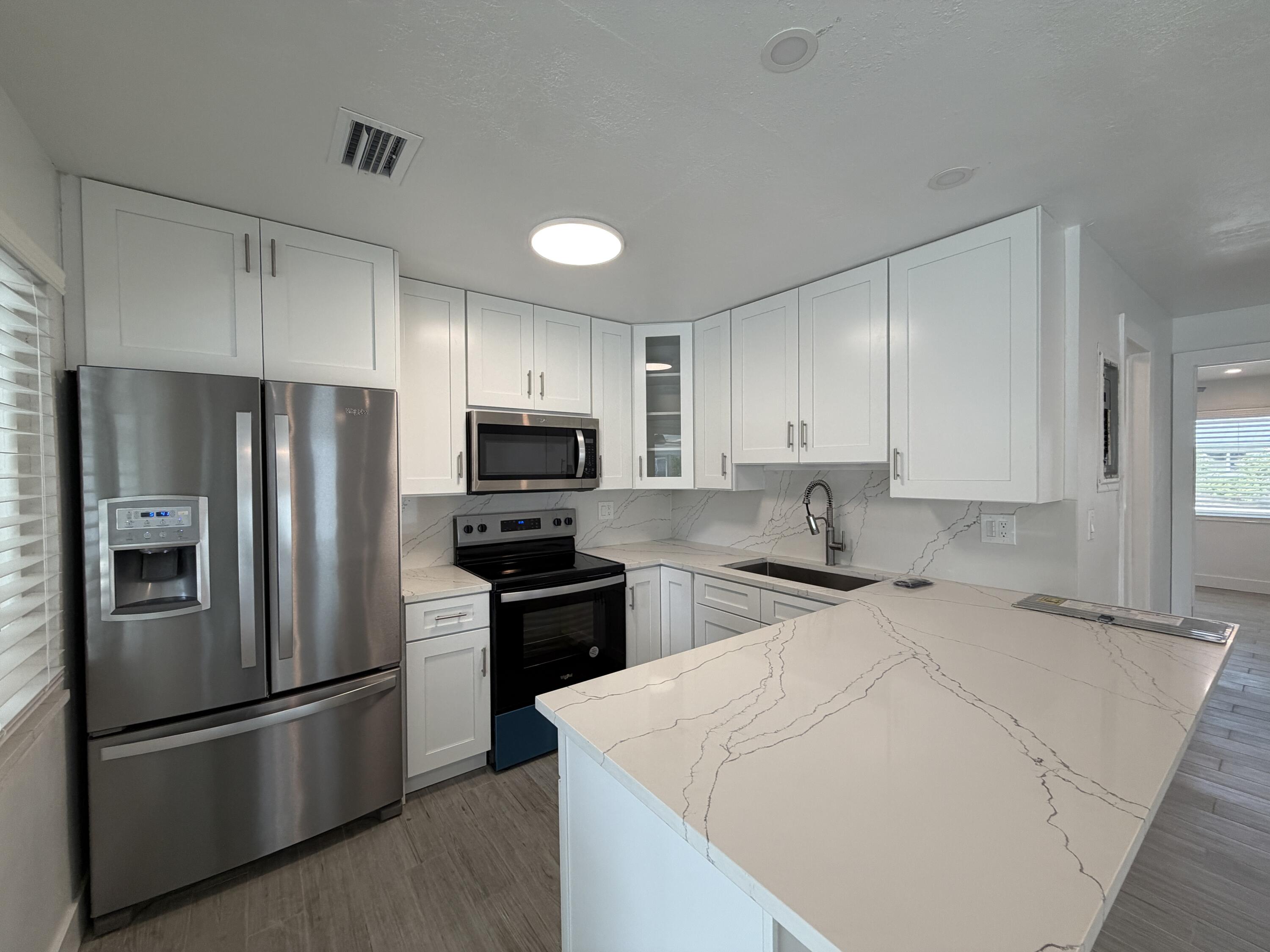 a kitchen with stainless steel appliances a refrigerator stove microwave and cabinets