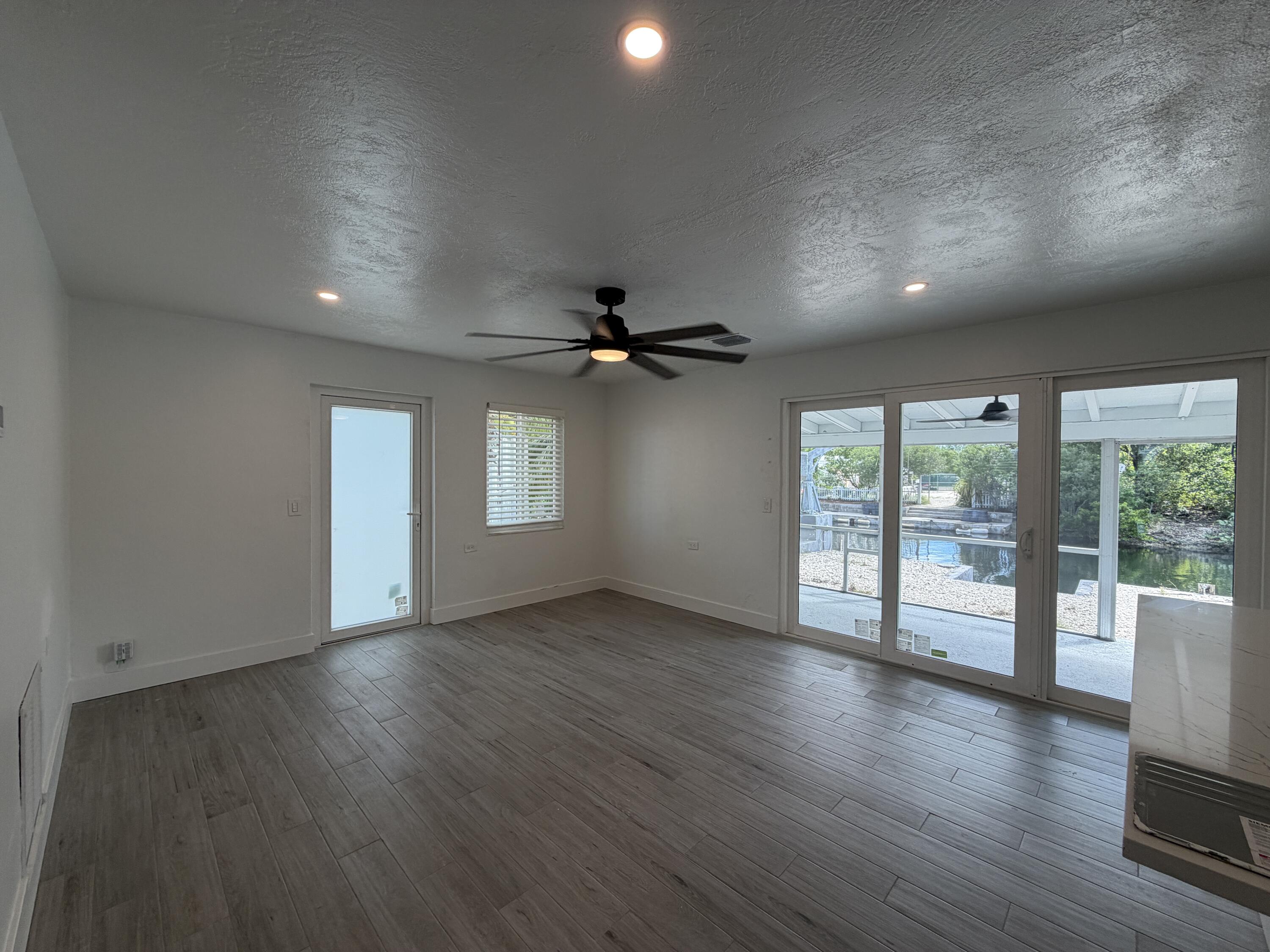 29656 Constitution Avenue Big Pine Key, FL 33043 - Photo 15 of 19 an empty room with wooden floor and windows