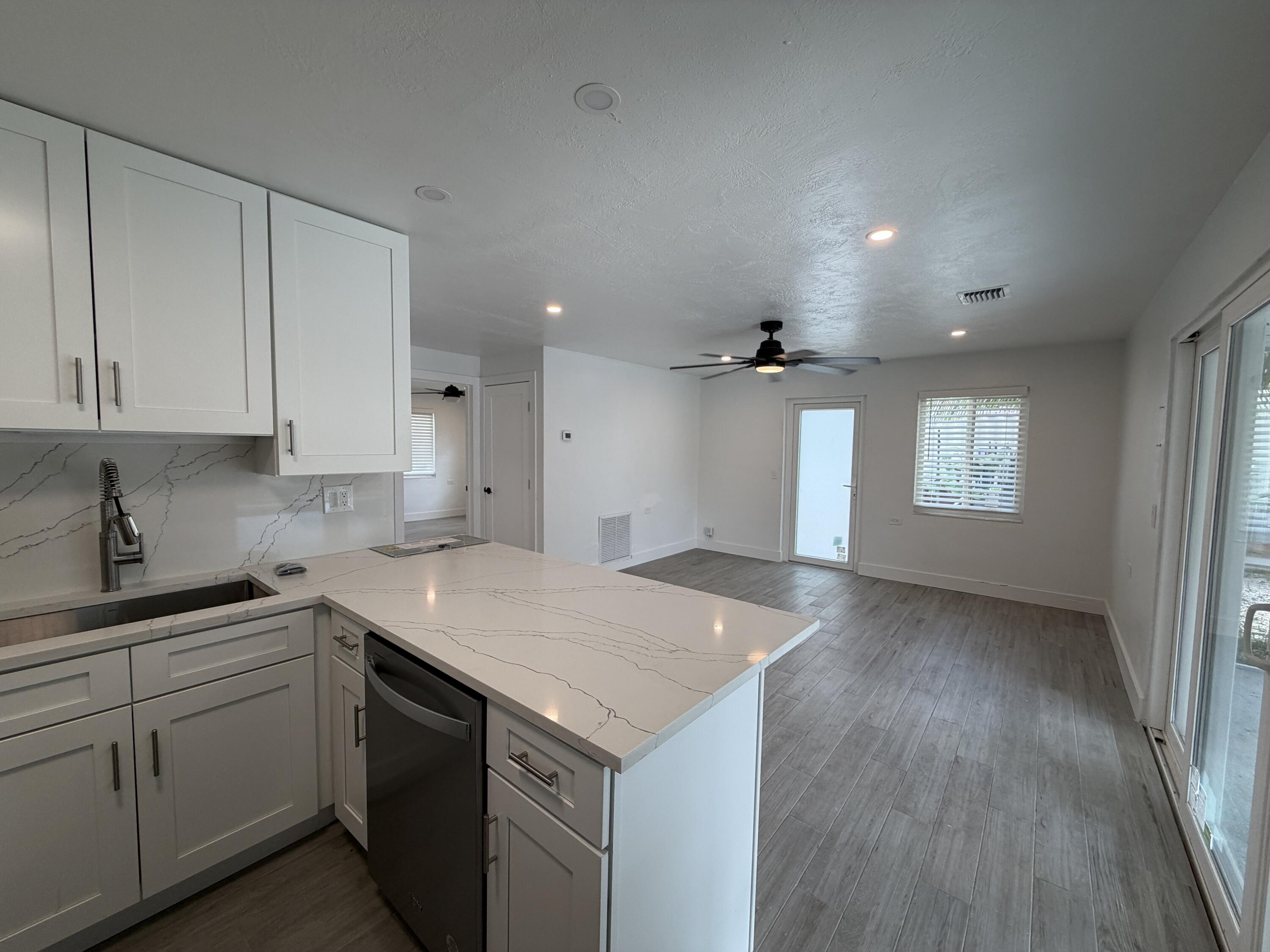 29656 Constitution Avenue Big Pine Key, FL 33043 - Photo 8 of 19 a kitchen with a sink dishwasher and white cabinets with wooden floor