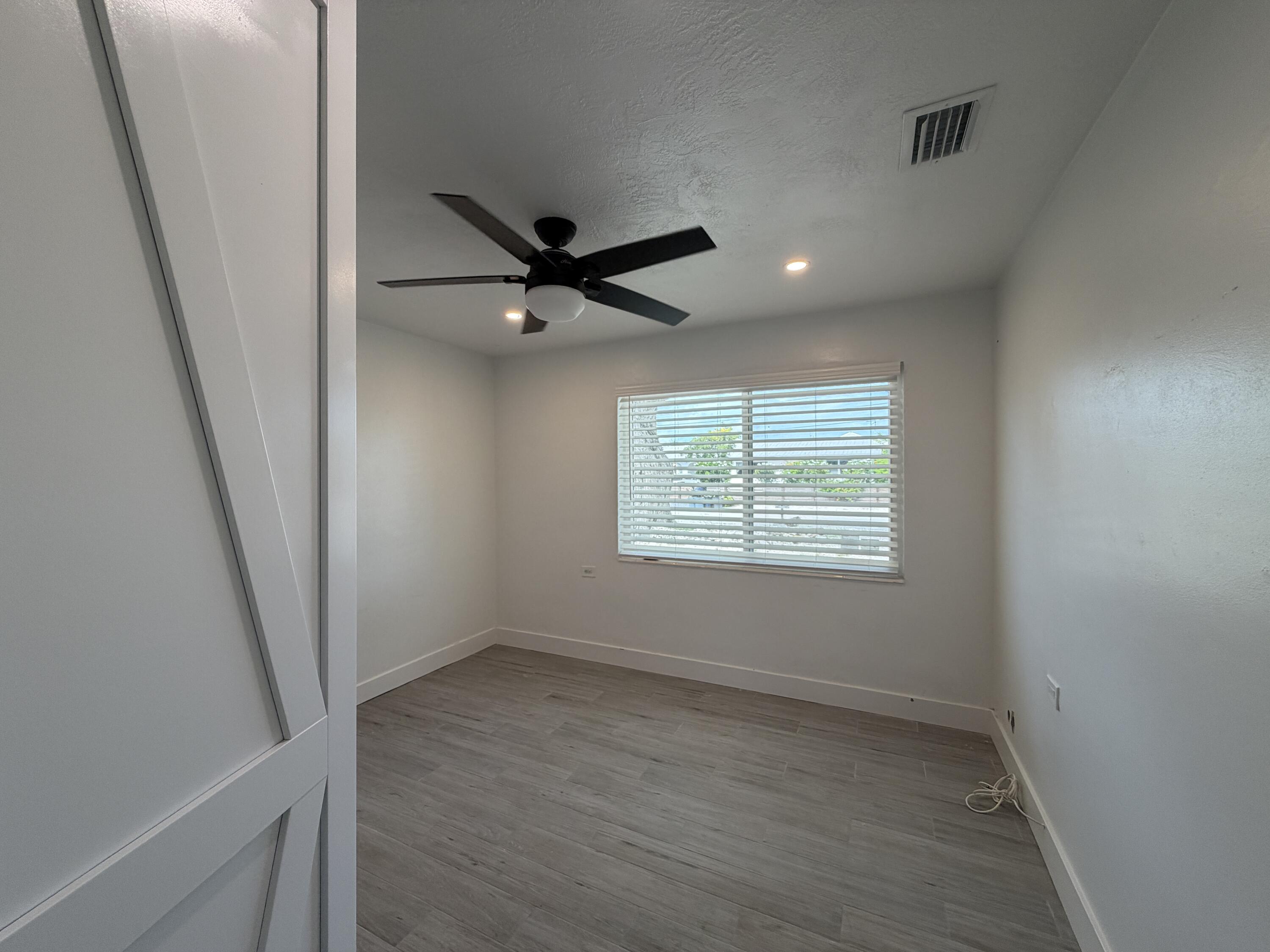 29656 Constitution Avenue Big Pine Key, FL 33043 - Photo 9 of 19 an empty room with wooden floor and windows