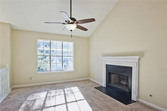 a view of an empty room with a window and fireplace