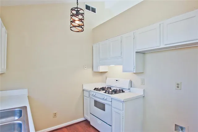 a kitchen with granite countertop white cabinets and white appliances