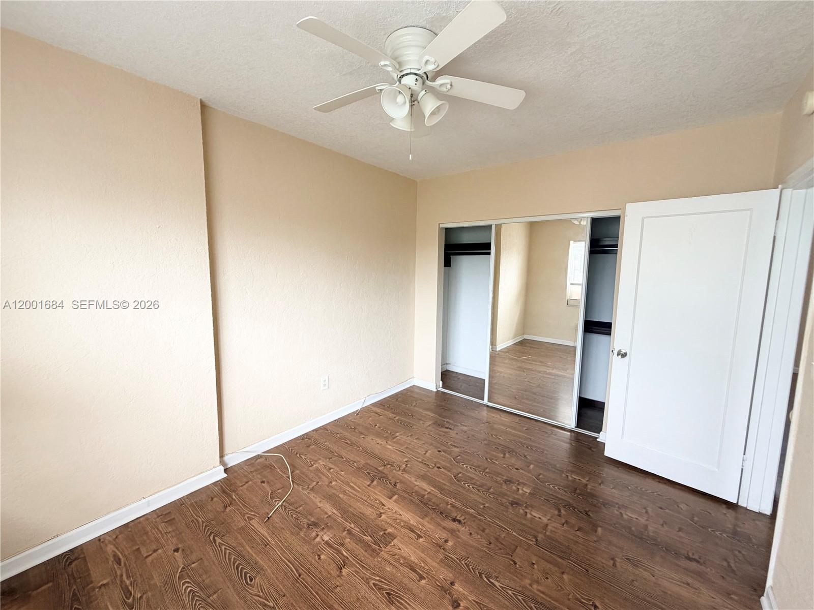 620 84th Street, Unit 25 Miami Beach, FL 33141 - Photo 7 of 12 wooden floor in an empty room with a window