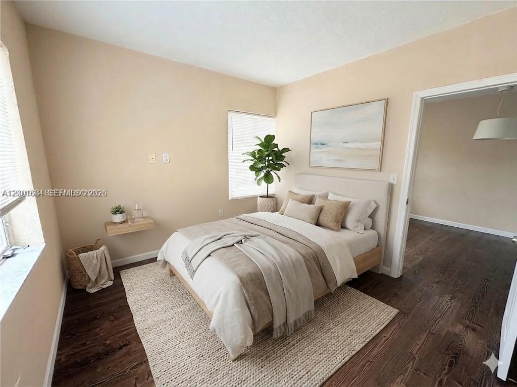 620 84th Street, Unit 25 Miami Beach, FL 33141 - Photo 8 of 12 a bedroom with a bed and wooden floor