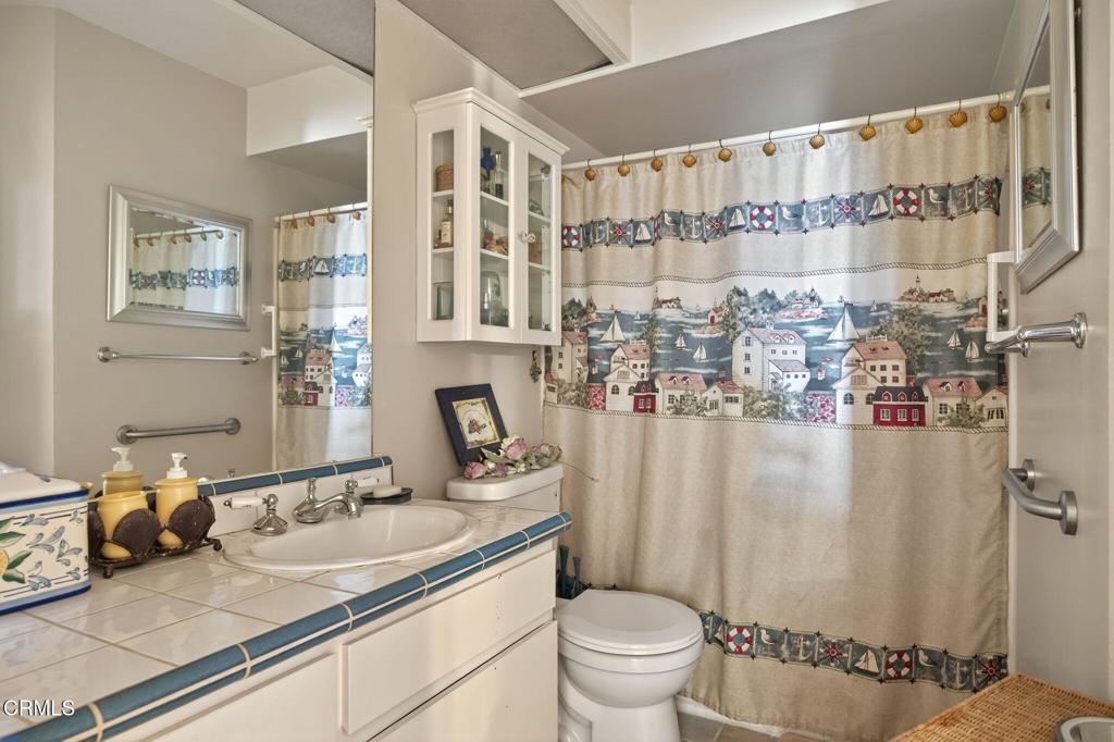2901 Peninsula Road, Unit 333 Oxnard, CA 93035 - Photo 7 of 14 a bathroom with a granite countertop sink and a mirror