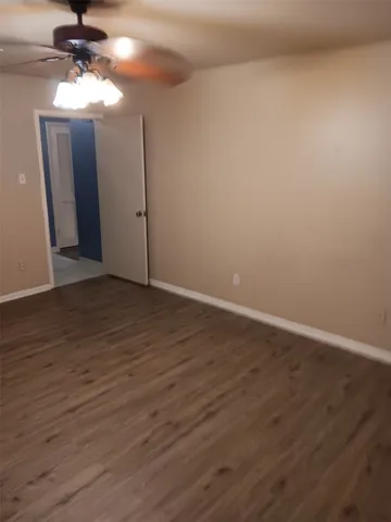 a view of a room with wooden floor and fan