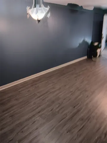 a view of a space with wooden floor and a window