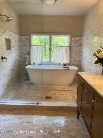 a bathroom with a granite countertop sink and a bathtub