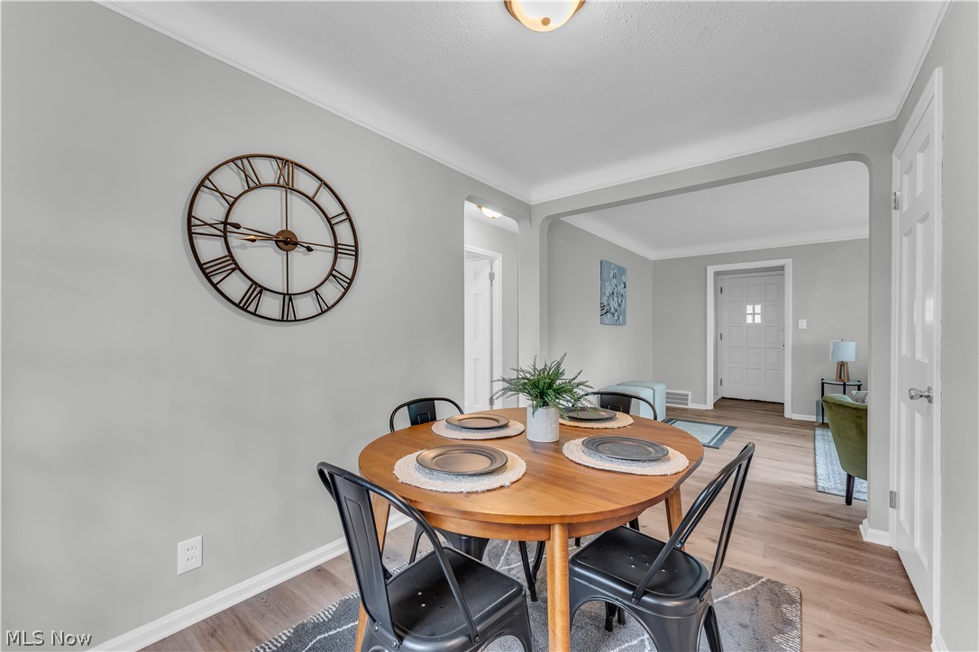 1828 South Green Road Cleveland, OH 44121 - Photo 7 of 30 Dining area with light hardwood / wood-style floors and ornamental molding