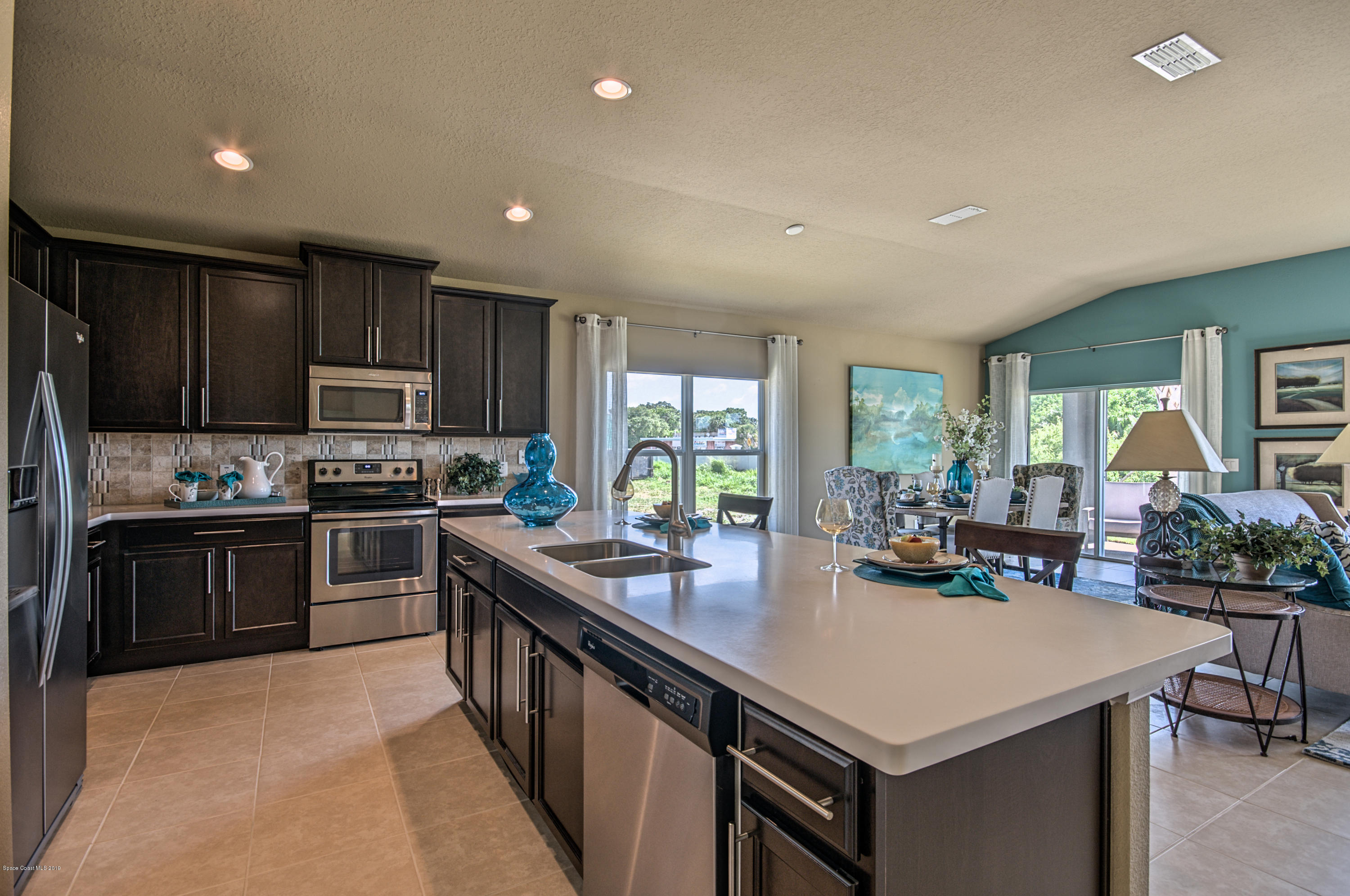 1027 Corbin Circle Southwest Palm Bay, FL 32908 - Photo 6 of 11 a kitchen with stainless steel appliances granite countertop a sink stove and refrigerator
