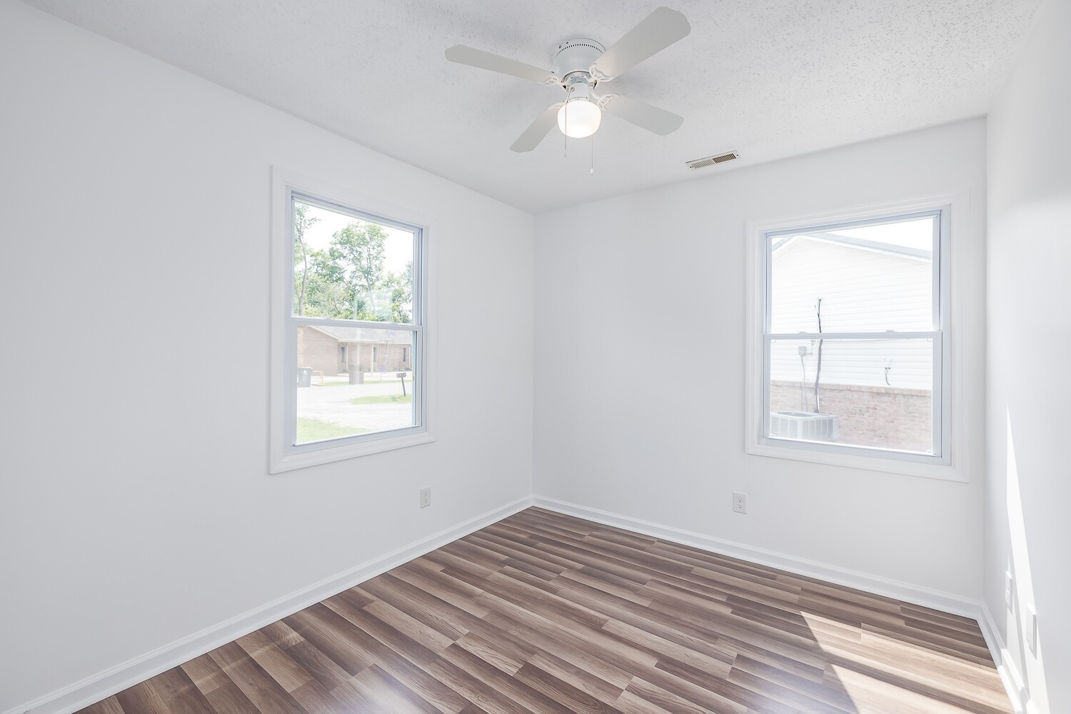 303 Burch Road Clarksville, TN 37042 - Photo 15 of 23 an empty room with wooden floor ceiling fan and windows
