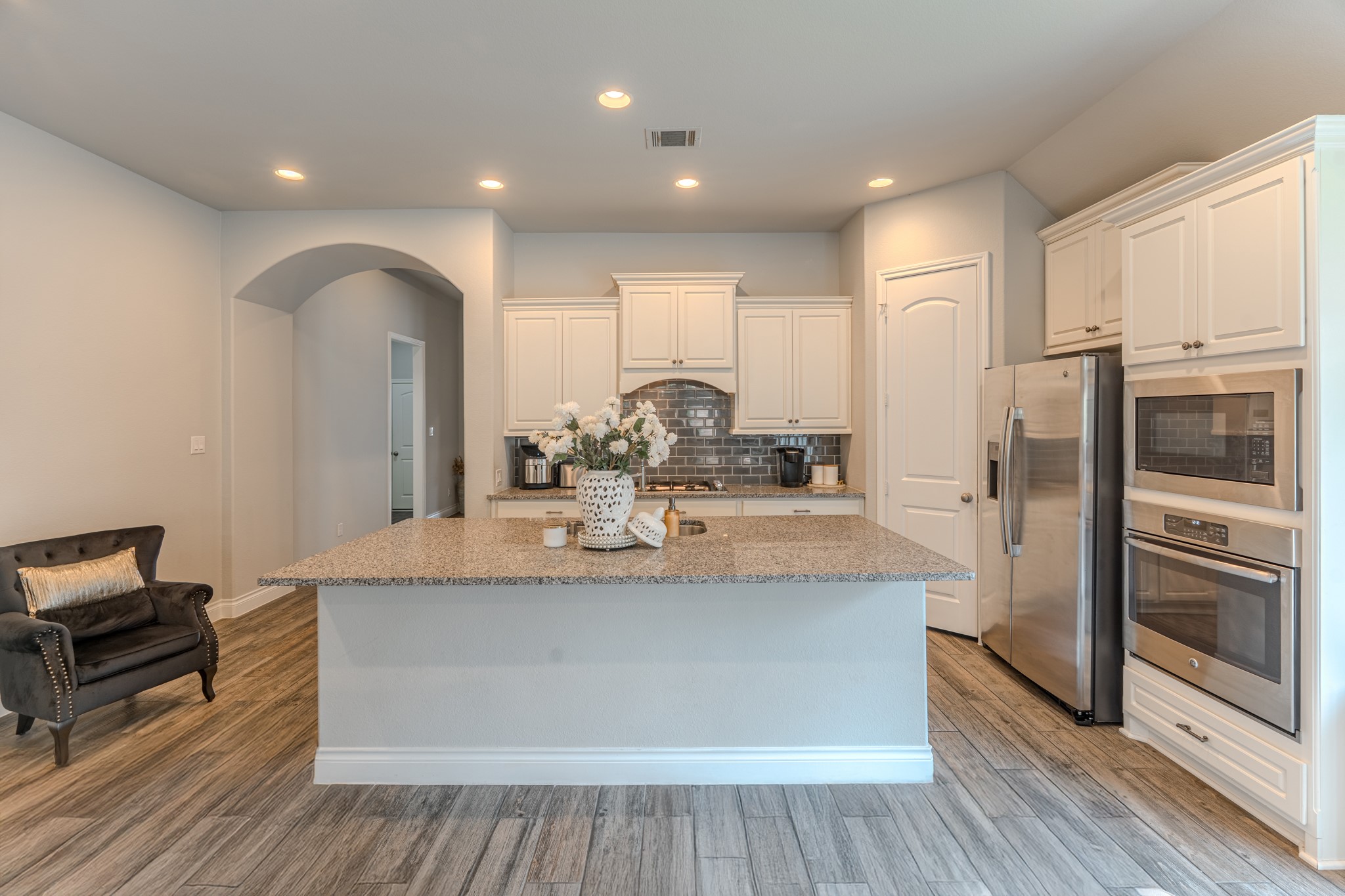 209 Trillium Park Loop Conroe, TX 77304 - Photo 15 of 50 a view of a kitchen with kitchen island a counter top space a refrigerator wooden floor and a stove top oven