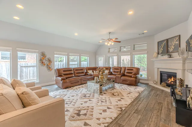 a living room with furniture large window and a fireplace