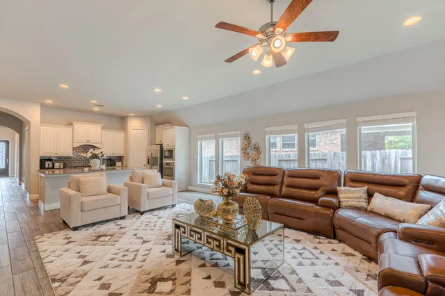 a living room with furniture ceiling fan and a rug