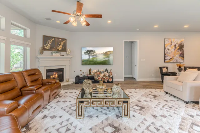 a living room with furniture a large window and a fireplace