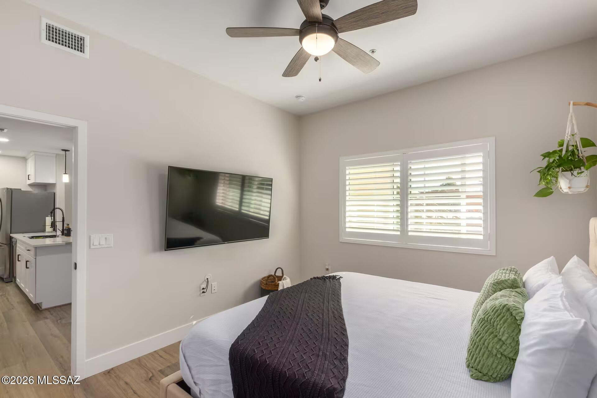 2036 East River Road, Unit 104 Tucson, AZ 85718 - Photo 10 of 23 a bedroom with a bed and a flat screen tv