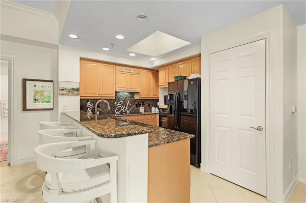 a kitchen with stainless steel appliances granite countertop a refrigerator and a sink