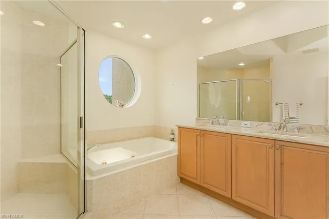 a bathroom with a tub a sink and mirror