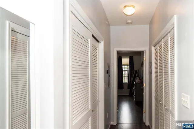a view of a hallway with hardwood and furniture