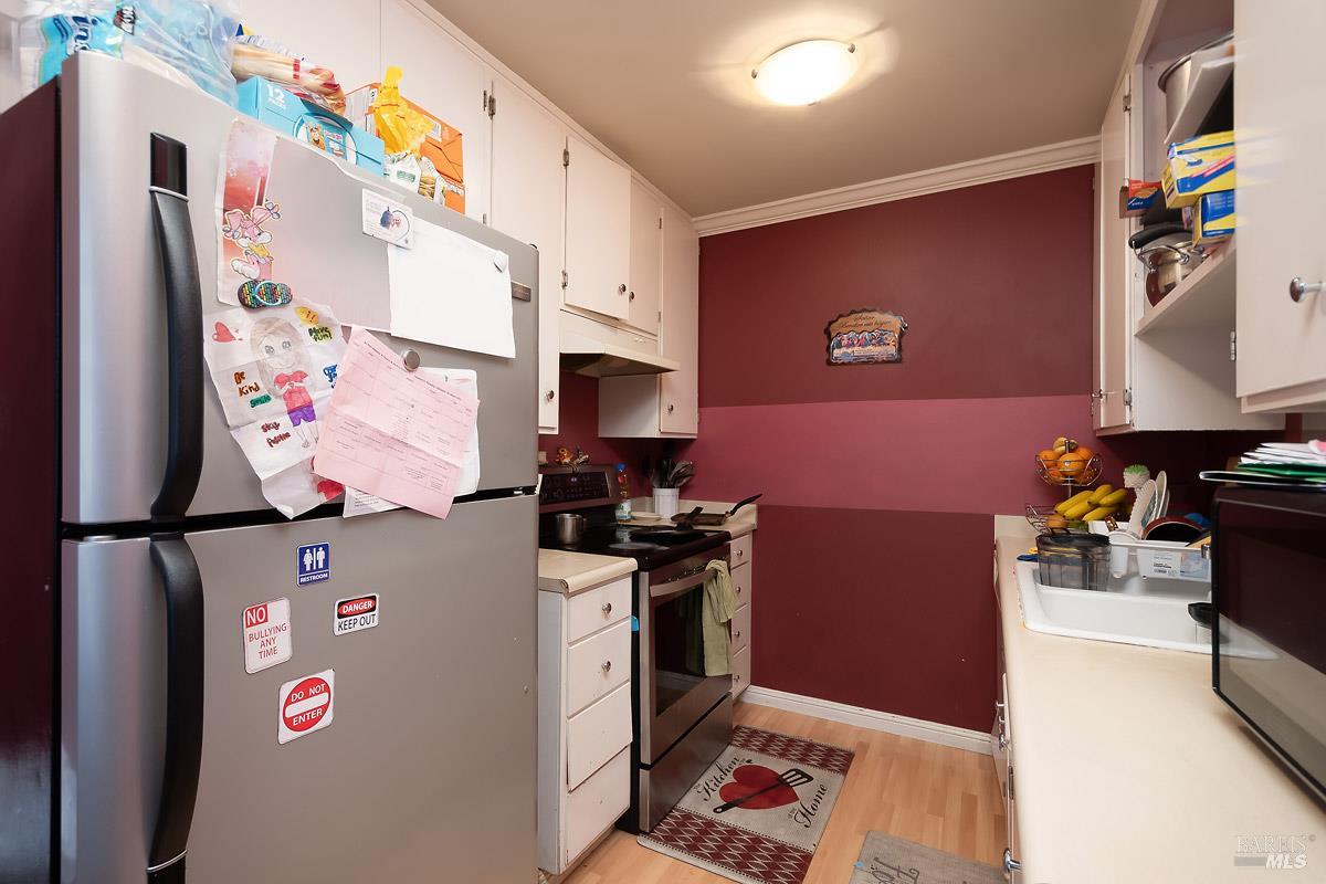 22 Fairfax Street, Unit E San Rafael, CA 94901 - Photo 5 of 7 a kitchen with stainless steel appliances granite countertop a refrigerator sink stove and cabinets