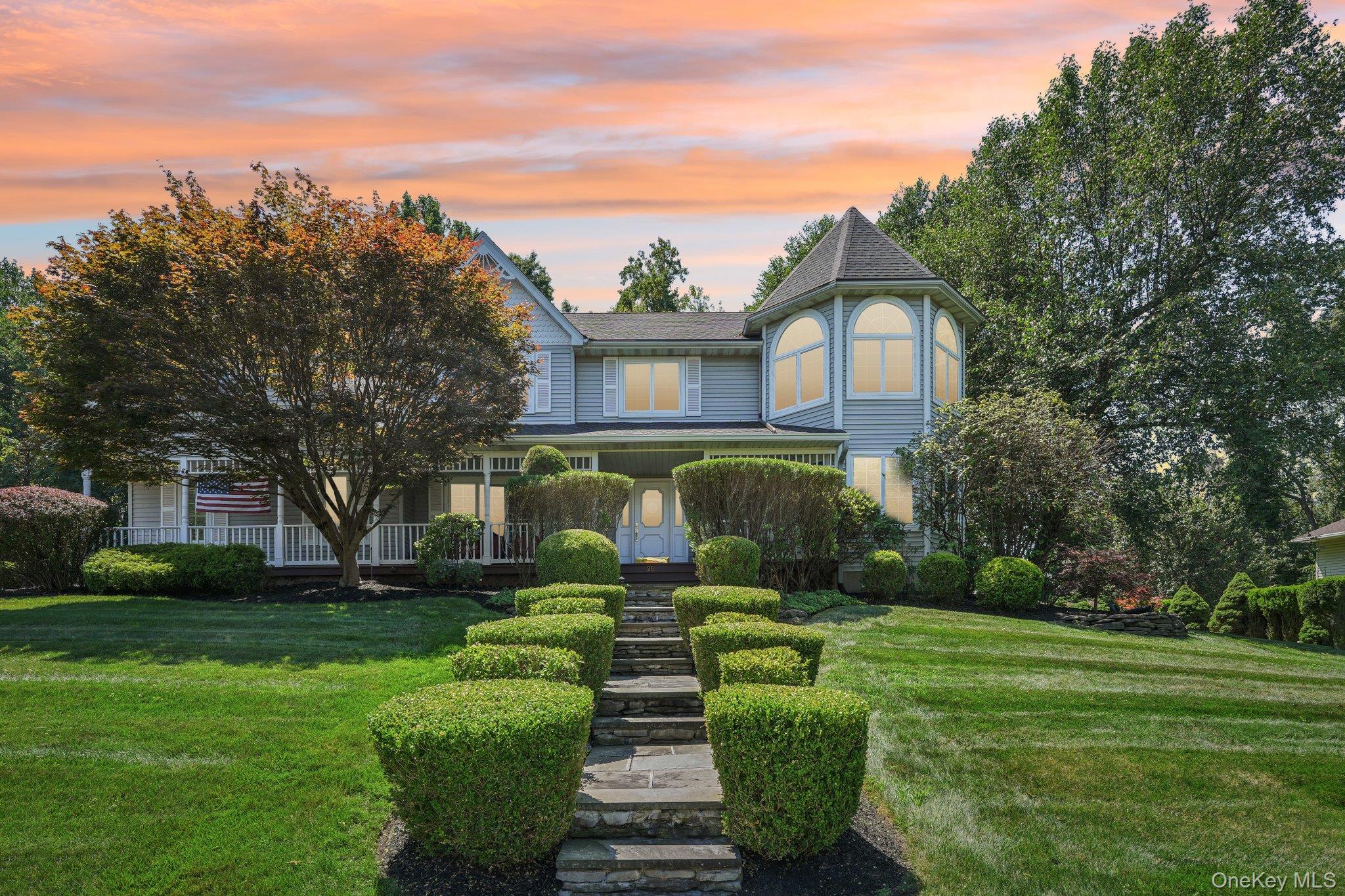 a front view of a house with a yard and trees