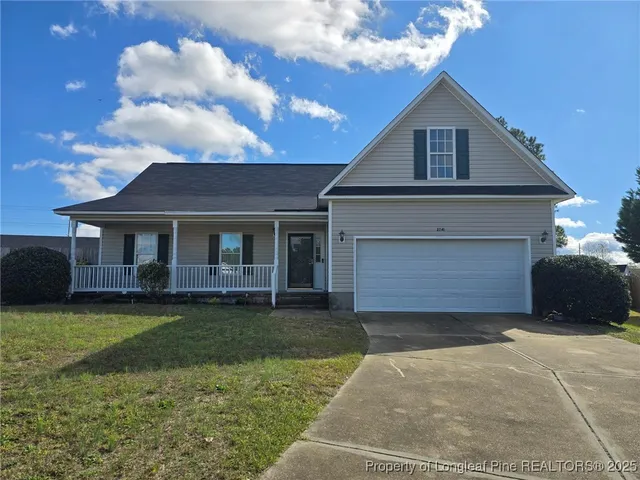 a view of a house with a yard and garage