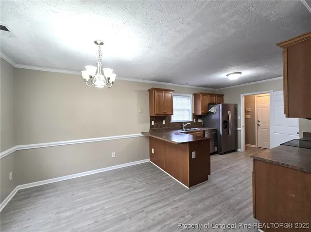 a kitchen with stainless steel appliances granite countertop a refrigerator and a stove top oven