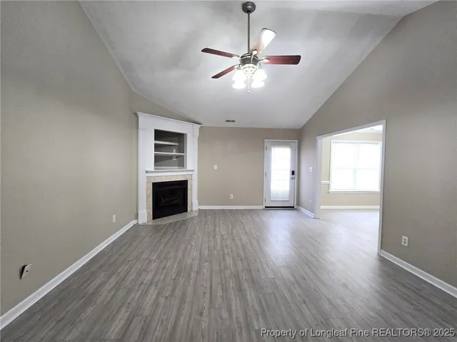 a view of empty room with wooden floor fireplace and windows