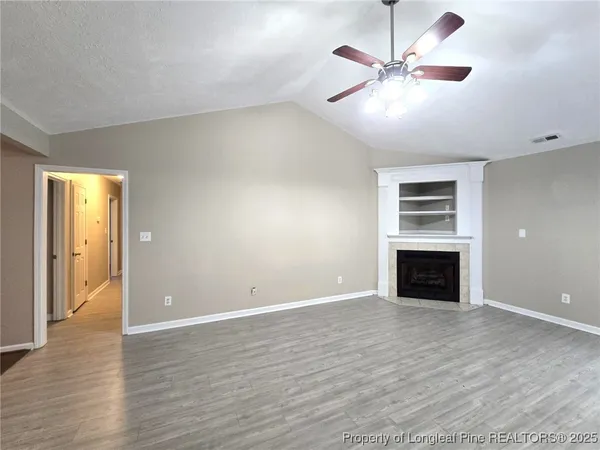 an empty room with windows and a fireplace