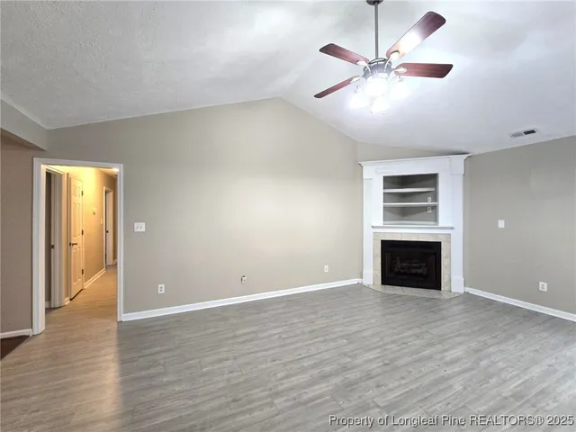 an empty room with windows and a fireplace