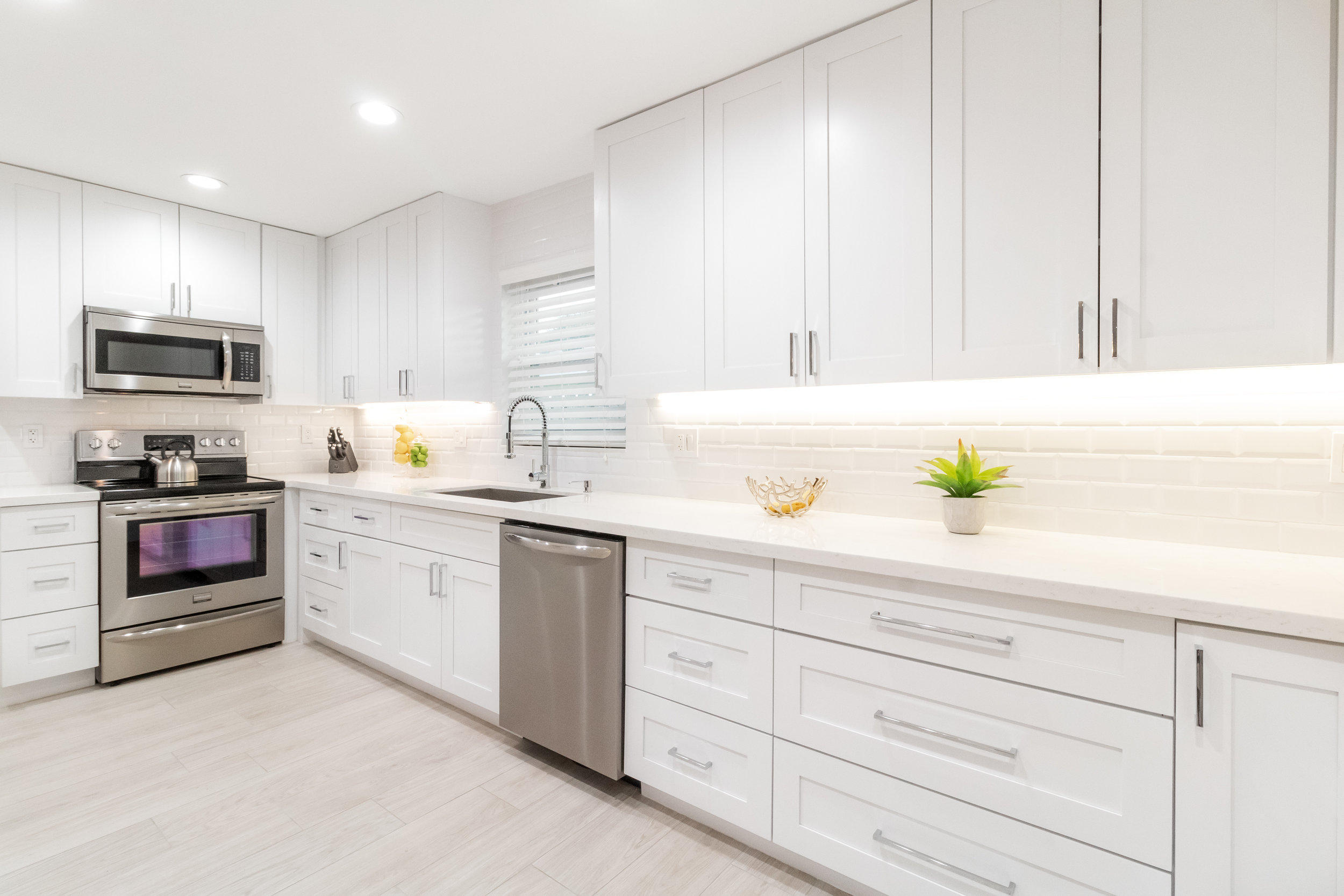 1241 Southwest 8th Street Boca Raton, FL 33486 - Photo 7 of 22 a kitchen with granite countertop white cabinets and stainless steel appliances