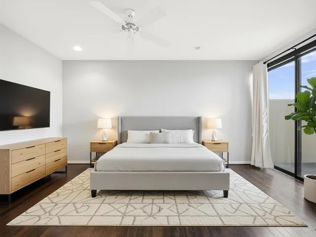 a bedroom with a large bed and a flat screen tv