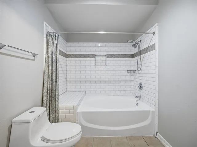a bathroom with a toilet and shower