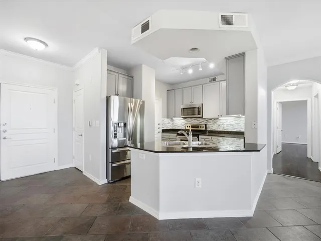 a kitchen with stainless steel appliances granite countertop a refrigerator and a stove