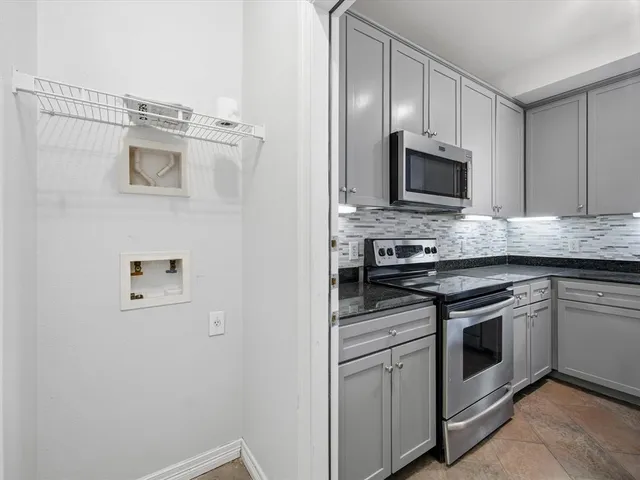 a kitchen with cabinets stainless steel appliances and a counter space